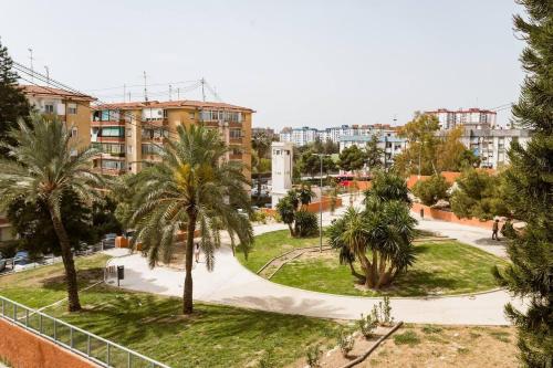 un parque en una ciudad con palmeras y edificios en Habitacion privada y tranquila, en Alicante