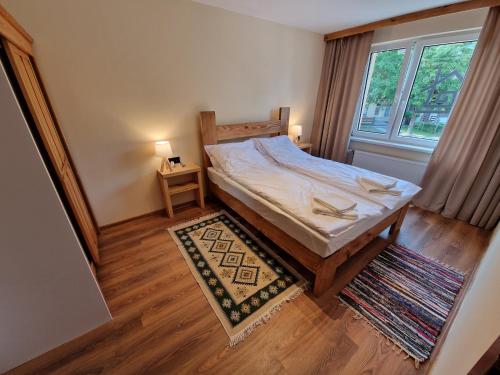 a bedroom with a bed and a window and a rug at 1 Maja 40A in Szczytno