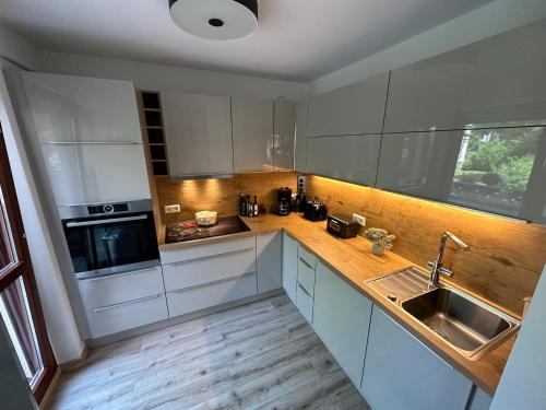 a kitchen with white cabinets and a sink at FHV01 - Ferienwohnung 100m² 6 Personen Garten und Terrasse 2x WC in Taucha
