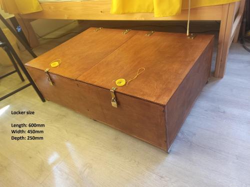 a wooden chest sitting on the floor next to a table at Evergreen Hostel Krakow in Kraków