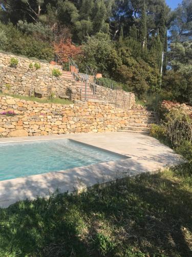 una piscina junto a una pared de piedra en Hauteurs de Toulon : Charmant studio piscine en Toulon