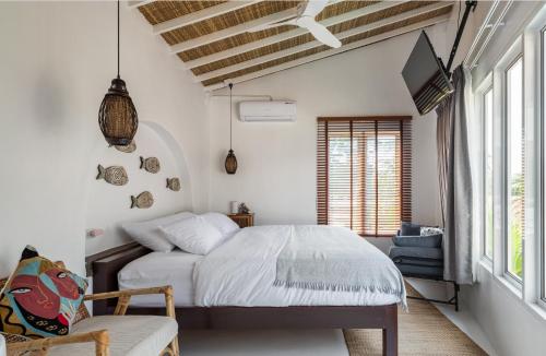 a bedroom with a bed and a tv and windows at lory‘s home in Bangkok