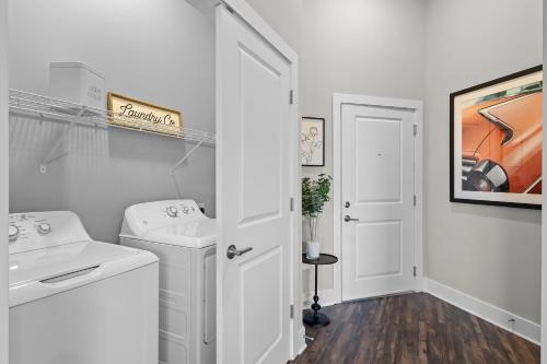 een witte badkamer met een wastafel en een wasmachine bij Mint House Greenville - West End in Greenville