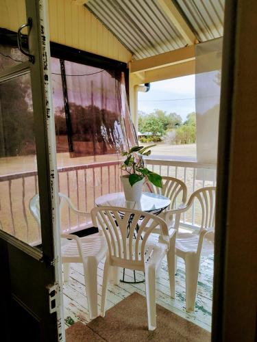 a table and chairs on a porch with a potted plant at Home at the beach in Ingham in Allingham