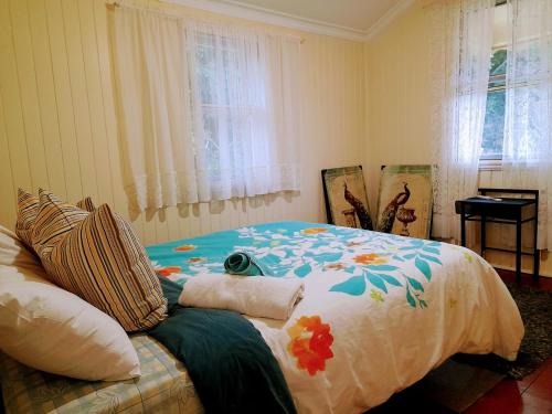 a bedroom with a bed with a flower blanket at Home at the beach in Ingham in Allingham