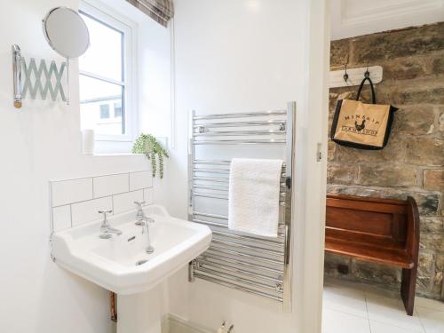 a bathroom with a sink and a mirror at Sycamore Cottage in Ashbourne
