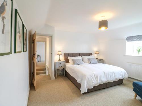 Un dormitorio con una gran cama blanca y una ventana en Sycamore Cottage, en Ashbourne