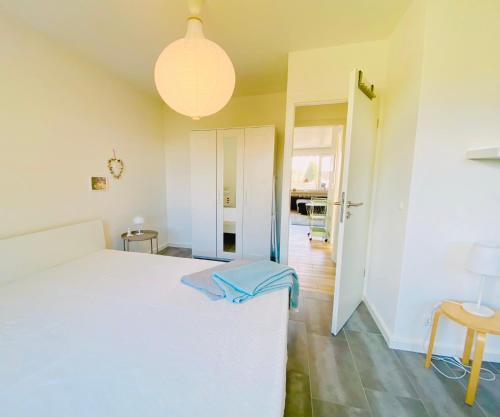 um quarto com uma cama branca e uma luz pendente em Beach inkl WLAN em Grömitz