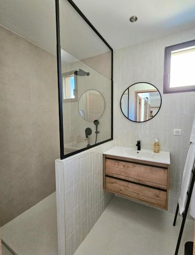 une salle de bain avec un lavabo et un miroir dans l'établissement Appartement prestige avc piscine - Village Furiani, à Furiani