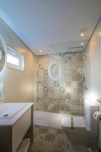 a bathroom with a shower and a toilet and a sink at A Tendinha - Guest House in Peso da Régua
