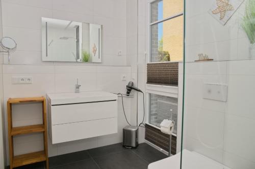 bagno bianco con lavandino e specchio di Sealoft Whg 2 inkl WLAN a Grömitz