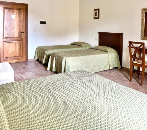 a room with two beds and a wooden door at Biagetti Bedrooms Affittacamere in Santa Maria degli Angeli