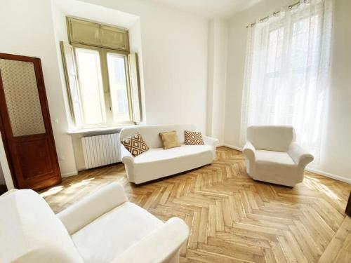 a living room with two white couches and two chairs at Dhouse antichità all'avanguardia in Reggio Emilia