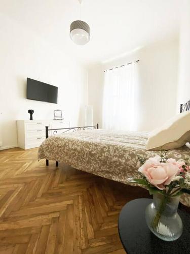 a bedroom with a bed and a vase with flowers at Dhouse antichità all'avanguardia in Reggio Emilia