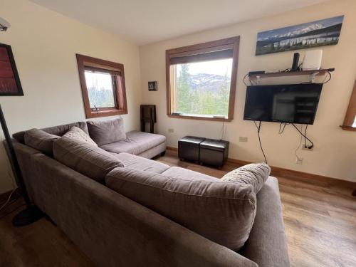 a living room with a couch and a flat screen tv at Denali Park View House in Healy