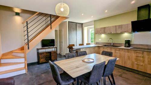 une cuisine avec une table en bois et quelques chaises dans l'établissement Le Clos des écureuils, à Sainte-Marie-la-Blanche