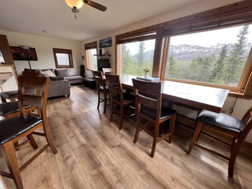a living room with a table and chairs and a couch at Denali Park View House in Healy