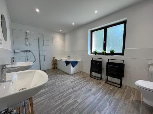 a large bathroom with two sinks and a tub at Traumhaus am Wald 1 in Weiersbach