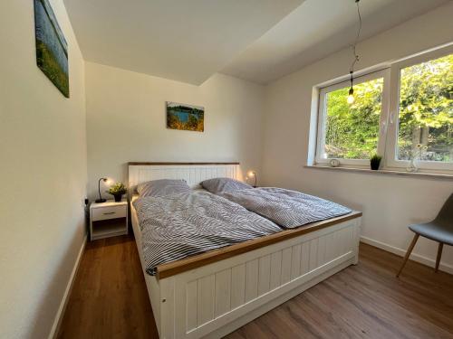 a bedroom with a bed in a room with a window at Traumhaus am Wald 1 in Weiersbach