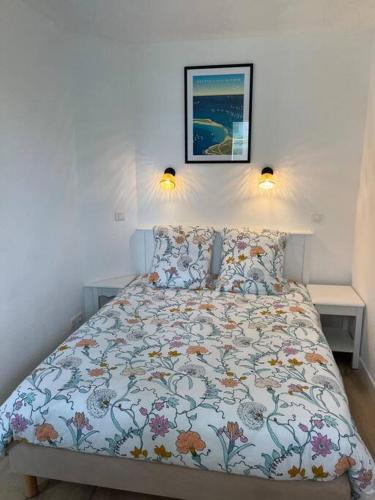 un lit dans une chambre avec deux lampes au mur dans l'établissement CAP COZ Plage, à Fouesnant