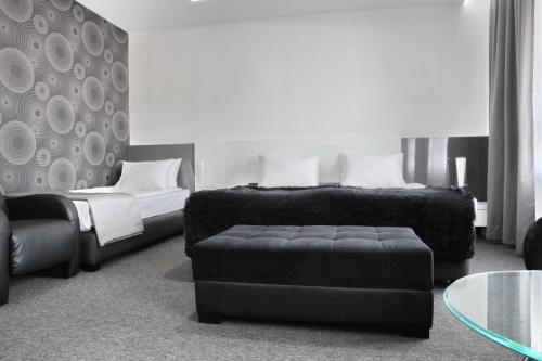 a bedroom with a bed and a chair and a couch at Nova City Garni Hotel Signature Collection in Belgrade