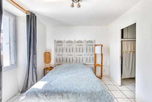 a white bedroom with a bed and a window at MONKEY PARADISE Bel appartement vue LOIRE in Bouchemaine