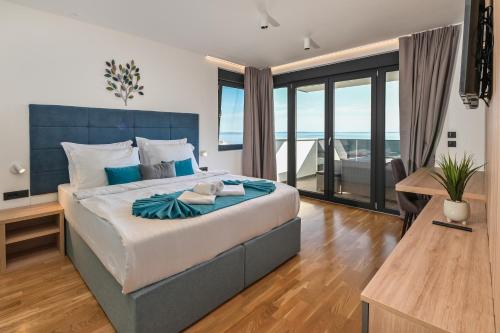 a bedroom with a large bed with a view of the ocean at Villa Luna-Private Heated Pool and sauna in Novalja