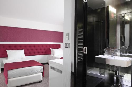 uma casa de banho com uma cama, um lavatório e um chuveiro em Nova City Garni Hotel Signature Collection em Belgrado