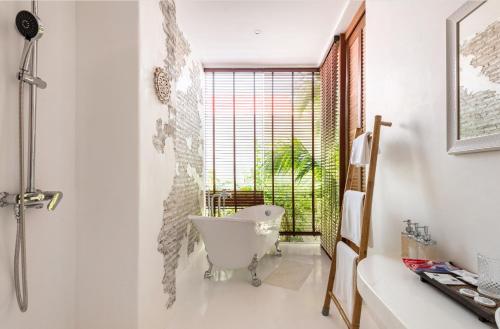 a bathroom with a white tub and a window at lory‘s home in Bangkok