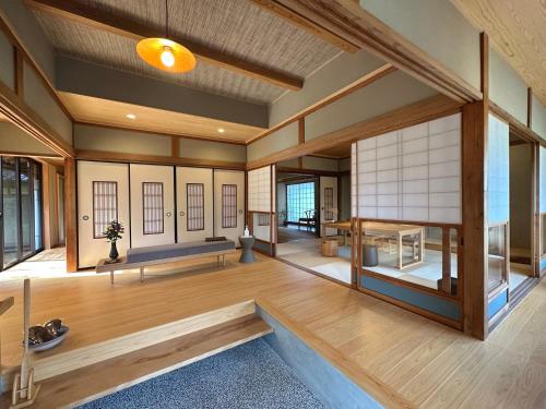 a large room with wooden floors and windows at shukubo michiru 満行寺 in Hagi