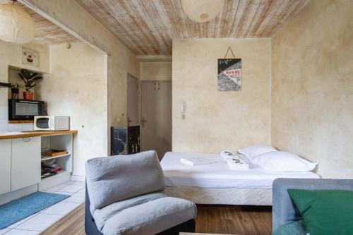 Habitación pequeña con cama y silla en Luminous studio in the center of Avignon - Welkeys, en Aviñón