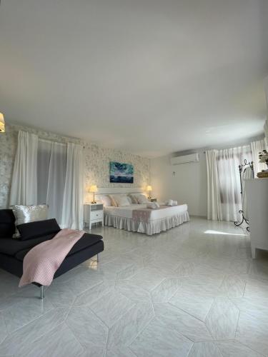 a large bedroom with two beds and a couch at Villa Garrido in Portocolom