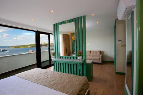 a room with a bed and a view of the water at Çanakkale Bosphorus Port Aspen Hotel in Çanakkale