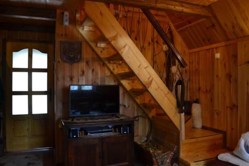 ein Wohnzimmer mit einer Treppe in einem Blockhaus in der Unterkunft Vikendica Verusa in Veruša