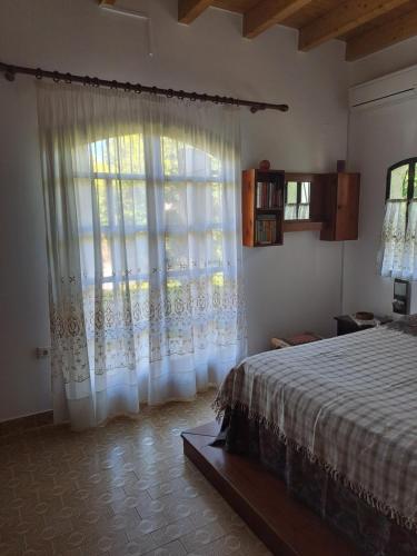 a bedroom with a bed and a large window at Villa Anesis-Παραθαλάσσια βίλα in Amaliás