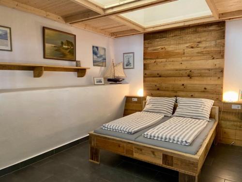 1 dormitorio con 1 cama con pared de madera en Pferdestall - a87338, en Kiel