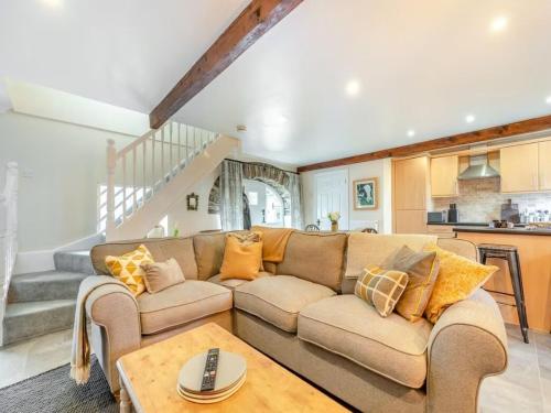 a living room with a couch and a table at The Stable, Cuffern Manor Cottages in Haverfordwest