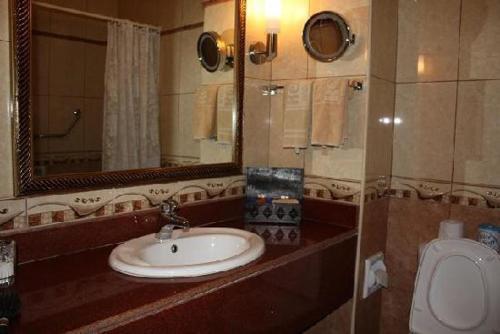 a bathroom with a sink and a toilet at Kenya Bay Beach Hotel in Bamburi