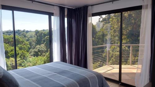 a bedroom with a bed and a large window at Casa de montaña Arisa in Cartago