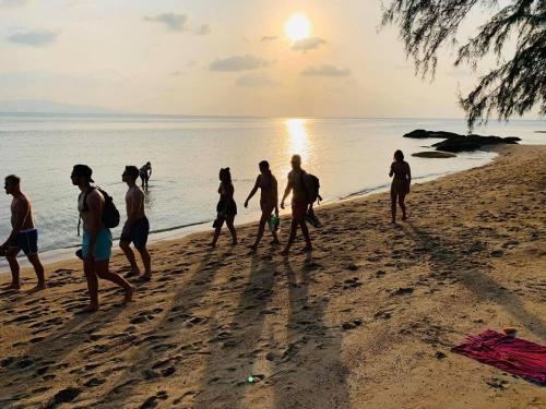 a group of people walking on the beach at Bird Bungalow Koh Phangan in Haad Rin