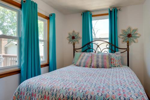 a bedroom with a bed with blue curtains at Lakefront Missouri Vacation Rental with Dock and Slip! in Camdenton