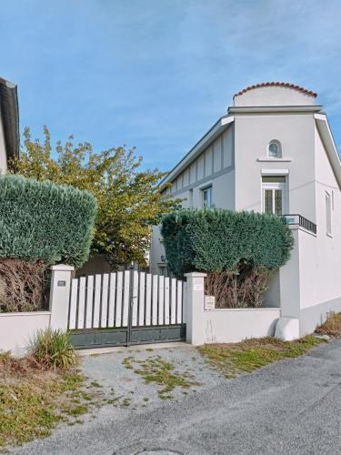 uma cerca branca em frente a uma casa em Appartement dans maison atypique em Montrond-les-Bains