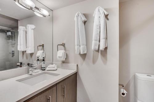 a white bathroom with a sink and a toilet at Interlude Condominiums 2-Bedroom Unit 101 in Snowmass Village