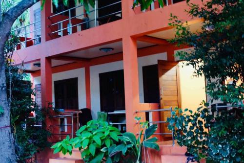 a red and white building with a porch at Bird Bungalow Koh Phangan in Haad Rin