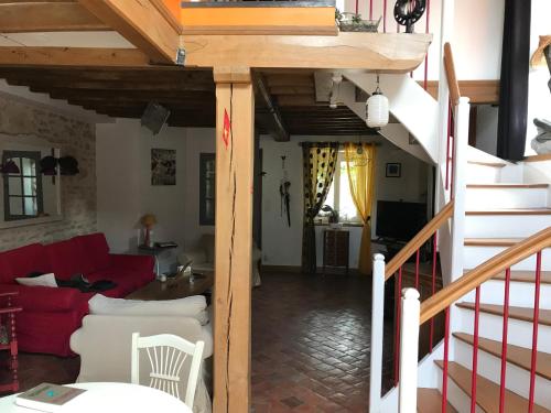 - un salon avec un canapé rouge et un escalier dans l'établissement chez domi, à Cessy-les-Bois