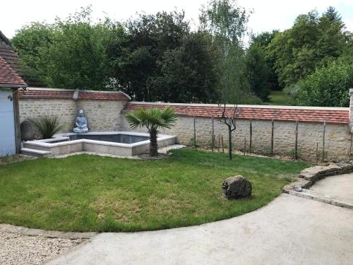 a garden with a fountain in the middle of a yard at chez domi 