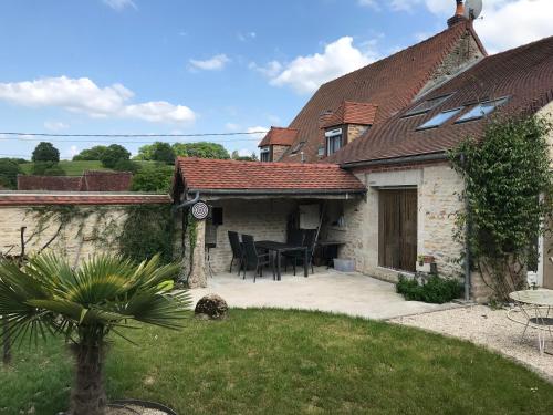 une maison avec un patio avec une table et des chaises dans l'établissement chez domi, à Cessy-les-Bois