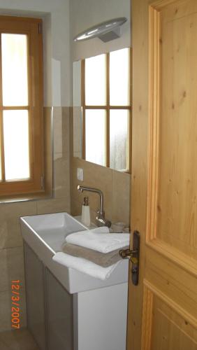 bagno con lavandino bianco e specchio di Ferienlodge Karwendelblick a Krün