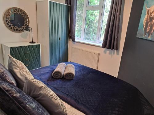 a bedroom with a bed with two slippers on it at Manse Apartment in Great Malvern