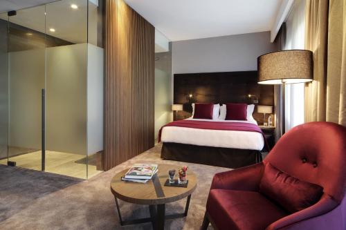 a hotel room with a bed and a red chair at Grand Hotel Campione in Campione dʼItalia